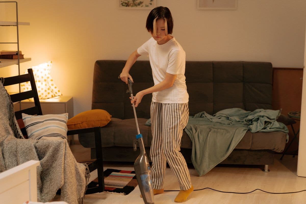 Ev temizliğinde altın kurallar — salonun elektrikli süpürge ile toplanması